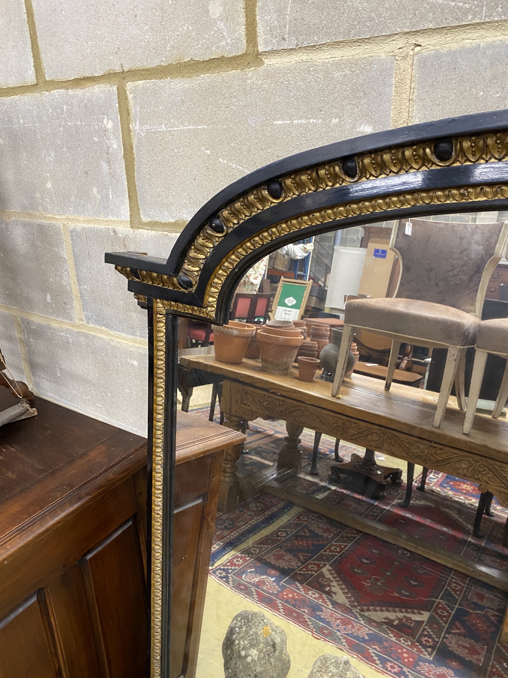 A late Victorian ebonised parcel gilt overmantel mirror, width 151cm, height 154cm